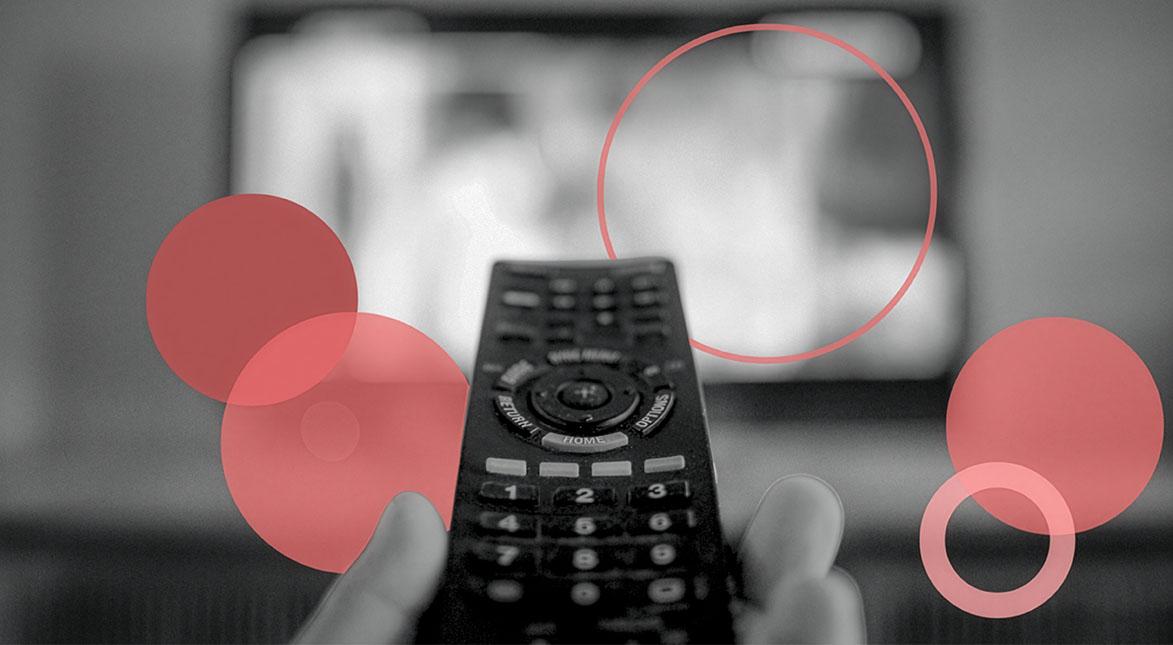 A hand holds a TV remote pointed at a blurred television screen in the background, with translucent red circles overlaid on the image.